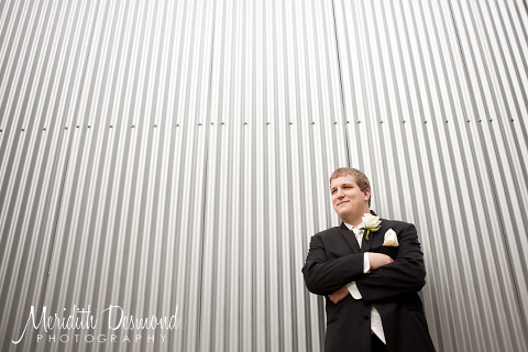 Groom against corrugated metal wall